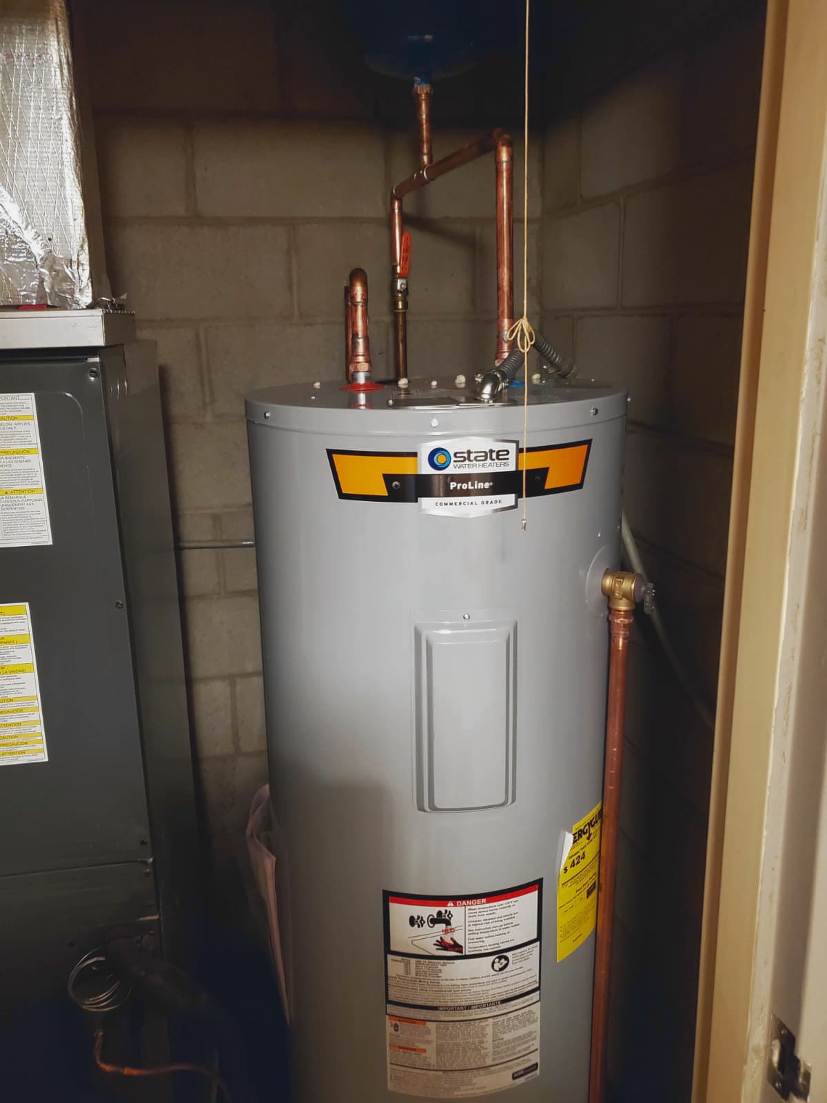 Water heater replacement in Evansville, IN — State ProLine tank with copper pipes in a utility closet